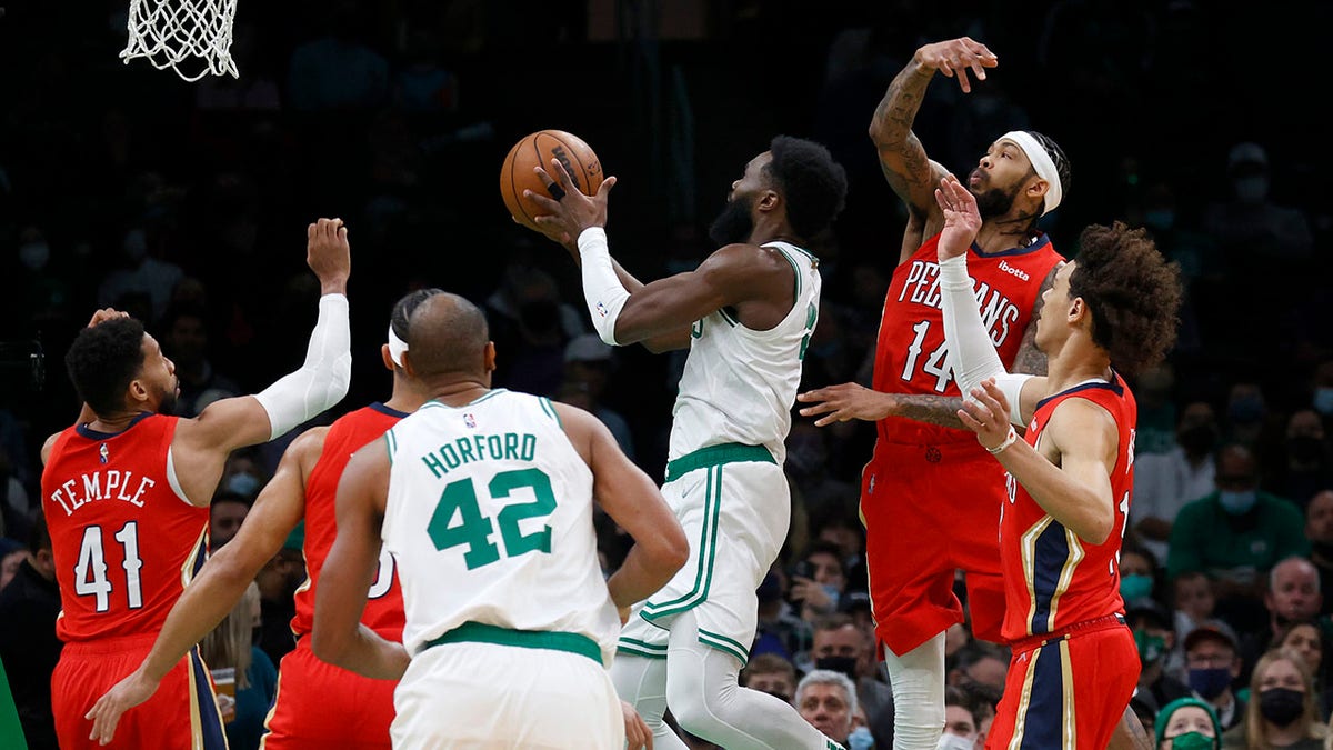Boston Celtics guard Jaylen Brown (7) drives to the basket ahead of New Orleans Pelicans forward Brandon Ingram (14) during the first half of an NBA basketball game, Monday, Jan. 17, 2022, in Boston.