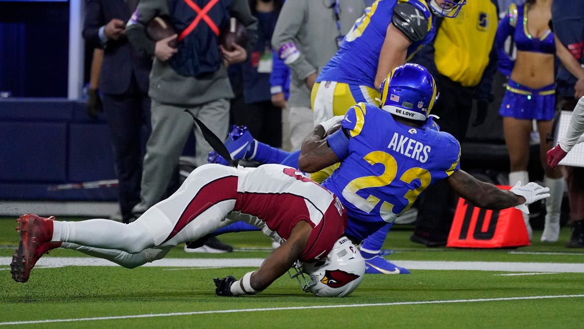 Arizona Cardinals safety Budda Baker, bottom, falls forward after tackling Los Angeles Rams running back Cam Akers (23) during the second half of an NFL wild-card playoff football game in Inglewood, Calif., Monday, Jan. 17, 2022. 