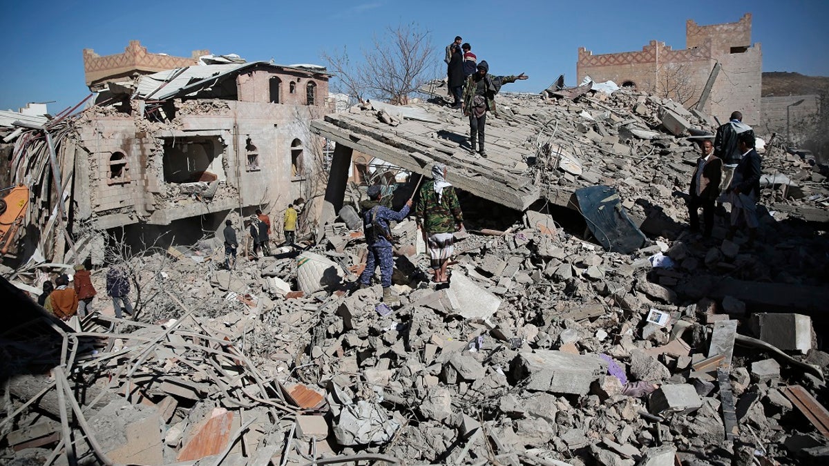 Yemenis inspect the wreckage of buildings after they were hit by Saudi-led coalition airstrikes, in Sanaa, Yemen, Tuesday, Jan. 18, 2022. (AP Photo/Hani Mohammed)