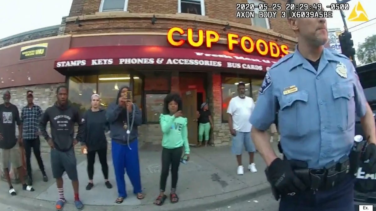 In this image from police body camera video former Minneapolis police Officer Derek Chauvin stands outside Cup Foods in Minneapolis, on May 25, 2020, with a crowd of onlookers behind him. 