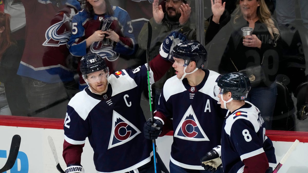 Colorado Avalanche right wing Mikko Rantanen, center, is congratulated after scoring a goal by left wing Gabriel Landeskog, left, and defenseman Cale Makar in the third period of an NHL hockey game against the Chicago Blackhawks Monday, Jan. 24, 2022, in Denver. The Avalanche won 2-0. 