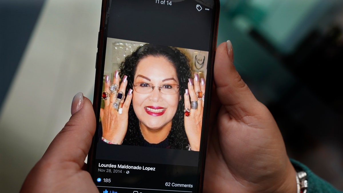 Renee Maldonado shows a photo of her aunt, Journalist Lourdes Maldonado who was shot and killed on Sunday, Jan. 23, at a funeral home during her wake in Tijuana, Mexico, Tuesday, Jan. 25, 2022. (AP Photo/Marco Ugarte)