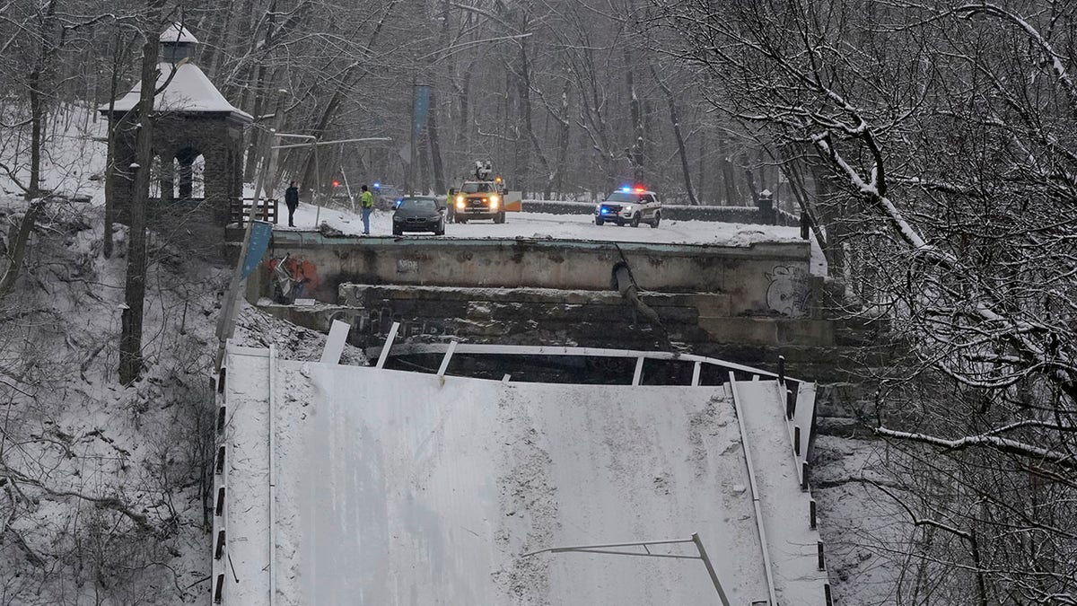 Emergency vehicles are parked at the edge of a bridge that collapsed Friday Jan. 28, 2022, in Pittsburgh's East End. 