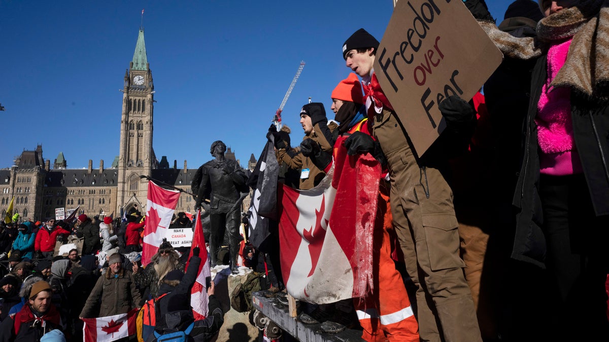 Protesters participating in a cross-country truck convoy protesting measures taken by authorities to curb the spread of COVID-19 and vaccine mandates gather near Parliament Hill in Ottawa on Saturday, Jan. 29, 2022. (Adrian Wyld/The Canadian Press via AP)