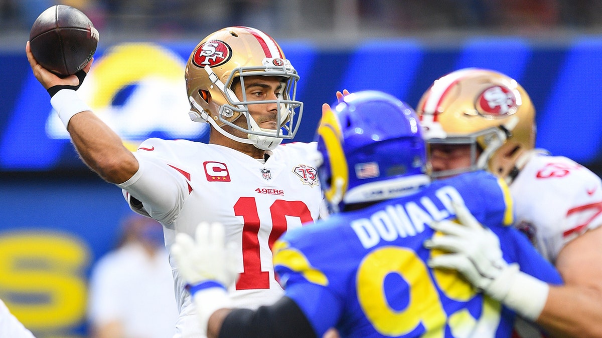 San Francisco 49ers quarterback Jimmy Garoppolo (10) throws a pass under pressure from Los Angeles Rams defensive tackle Aaron Donald (99) during the NFL game between the San Francisco 49ers and the Los Angeles Rams on Jan. 9, 2022, at SoFi Stadium in Inglewood, California.