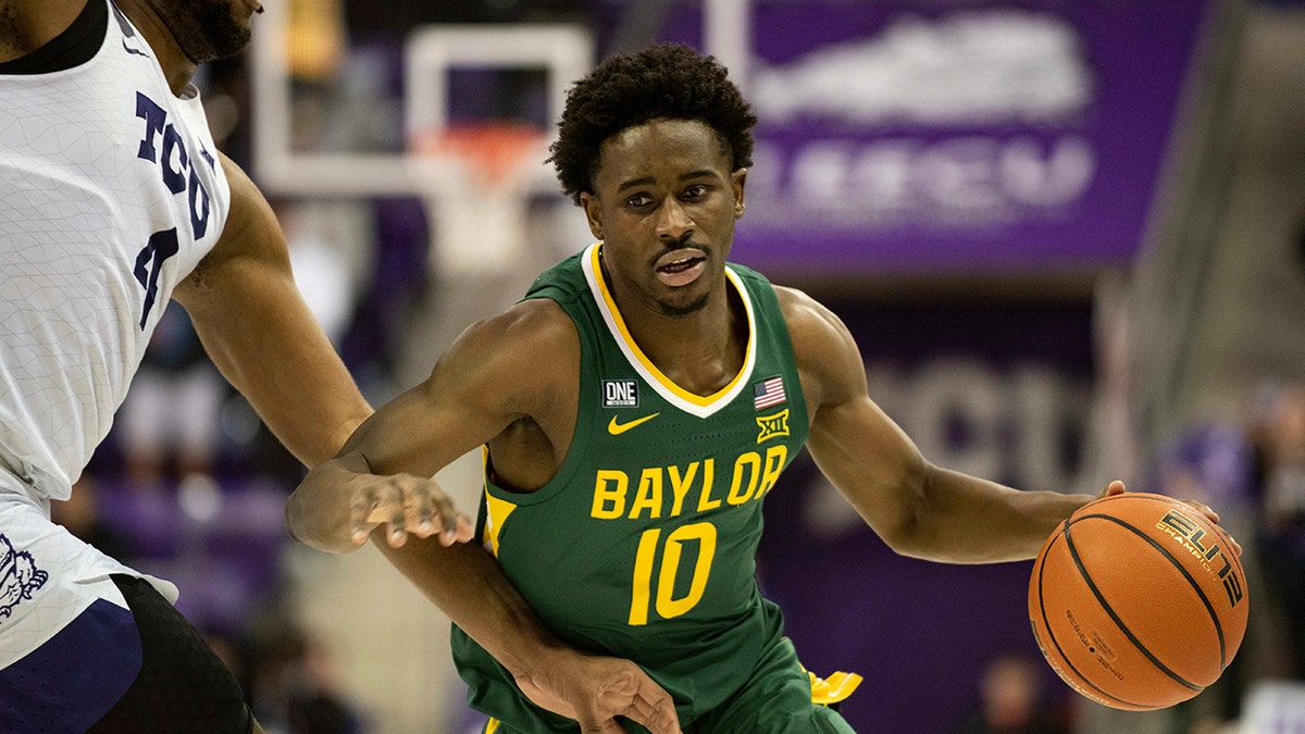 Baylor guard Adam Flagler (10) drives past TCU center Eddie Lampkin Jr. (4) to the basket in the first half of an NCAA college basketball game in Fort Worth, Texas, Saturday, Jan. 8, 2022.