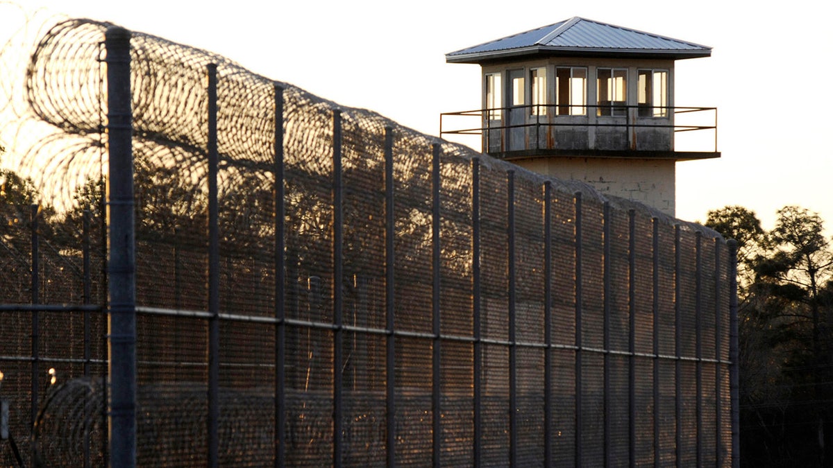 The sun sets behind Holman Prison in Atmore, Alabama, on Thursday, Jan. 27, 2022, as the U.S. Supreme Court considered whether to allow the execution of death row inmate Matthew Reeves, convicted of killing a man during a robbery in 1996. 