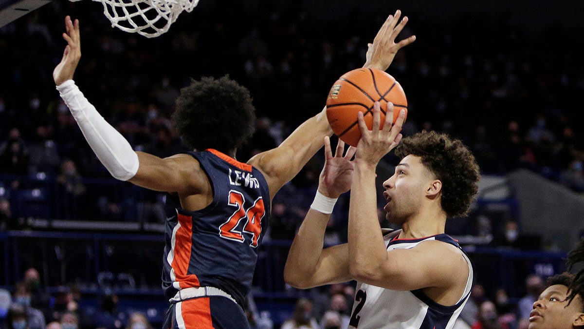Gonzaga forward Anton Watson, right, shoots while pressured by Pepperdine forward Maxwell Lewis during the second half of an NCAA college basketball game Saturday, Jan. 8, 2022, in Spokane, Wash. Gonzaga won 117-83.