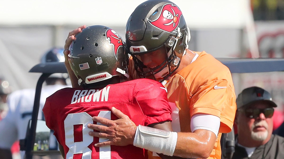 Antonio Brown (81) and Tom Brady (12) of the Buccaneers hug one another during the Tennessee Titans-Tampa Bay Buccaneers joint training camp on Aug. 19, 2021, at the AdventHealth Training Center at One Buccaneer Place in Tampa, Florida.