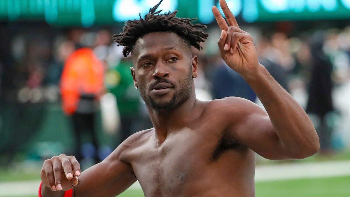 Tampa Bay Buccaneers wide receiver Antonio Brown gestures to the crowd as he leaves the field while his team's offense is on the field against the New York Jets during the third quarter of an NFL football game Sunday, Jan. 2, 2022, in East Rutherford, New Jersey. 