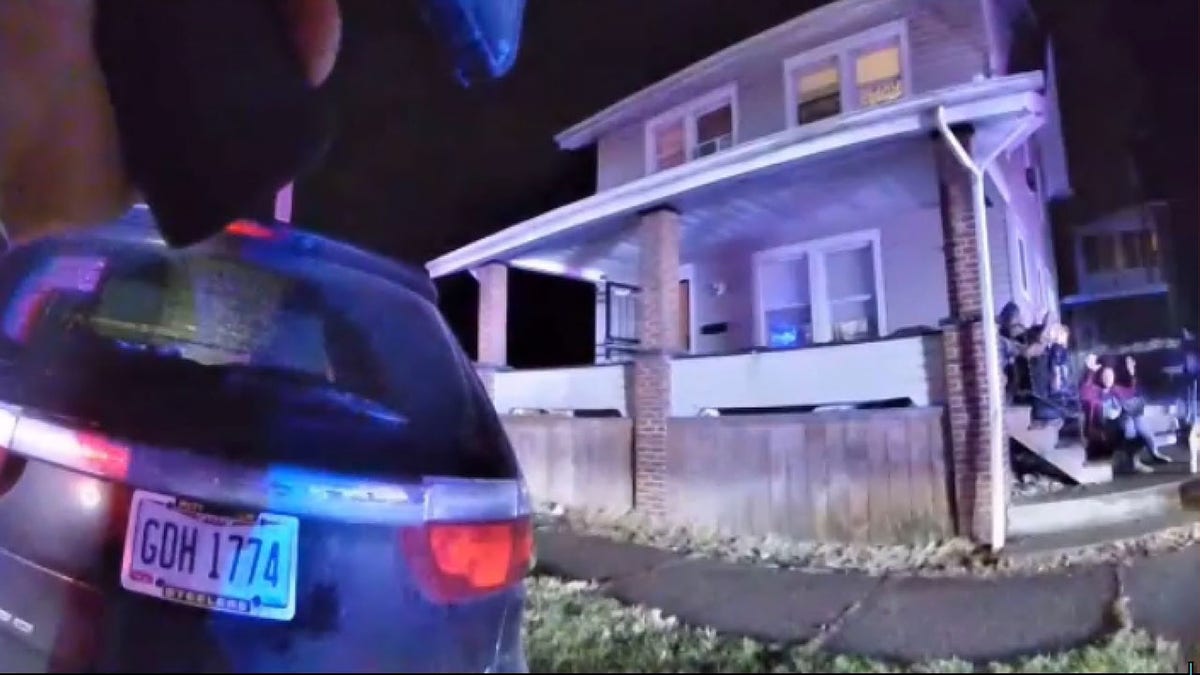 Still from body camera footage showing James Williams' family huddled on their steps