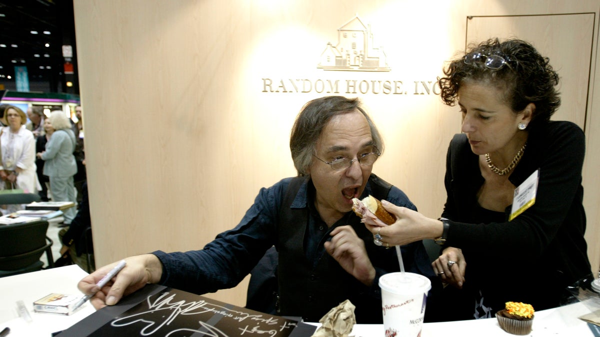 Artist and author Art Spiegelman gets some help with his lunch from Francoise Mouly, of Random House Inc., during a signing of Spiegelman's new book "In the Shadow of No Towers" at the Book Expo America convention, Saturday, June 5, 2004, in Chicago. 