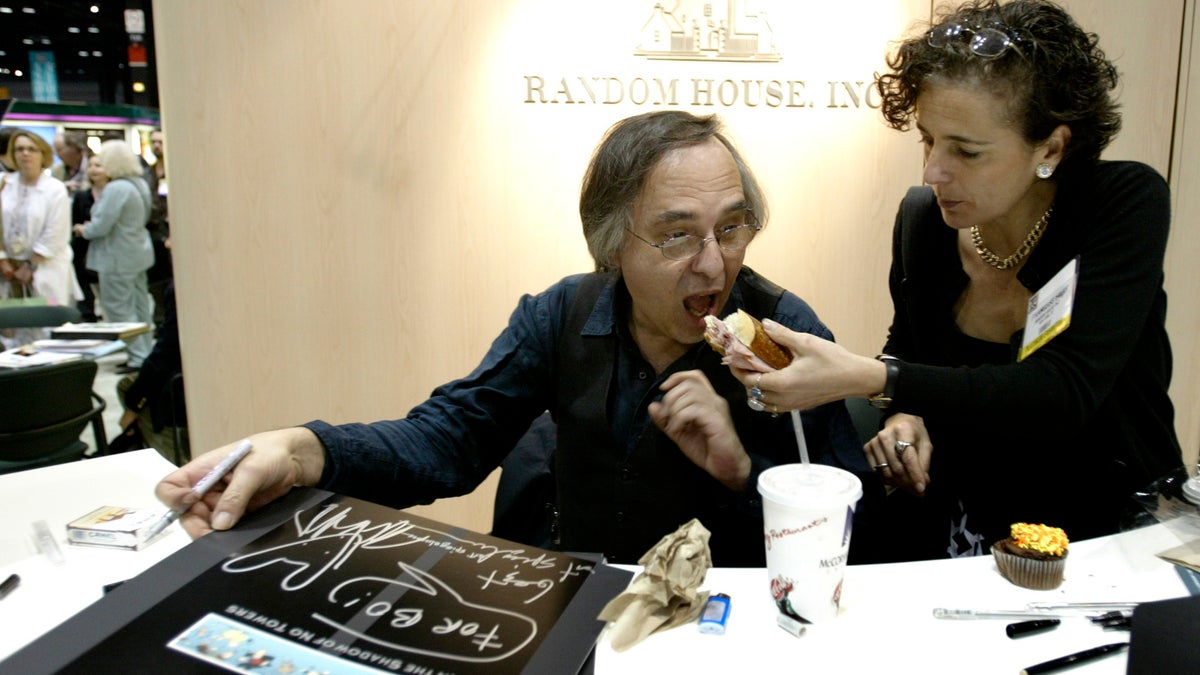 Artist and author Art Spiegelman gets some help with his lunch from Francoise Mouly, of Random House Inc., during a signing of Spiegelman's new book "In the Shadow of No Towers" at the Book Expo America convention, Saturday, June 5, 2004, in Chicago.