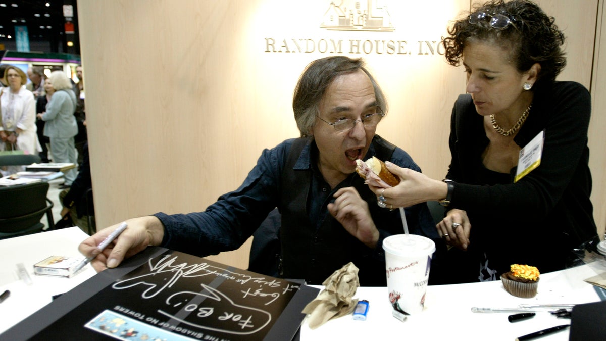 Artist and author Art Spiegelman gets some help with his lunch from Francoise Mouly, of Random House Inc., during a signing of Spiegelman's new book "In the Shadow of No Towers" at the Book Expo America convention, Saturday, June 5, 2004, in Chicago. 