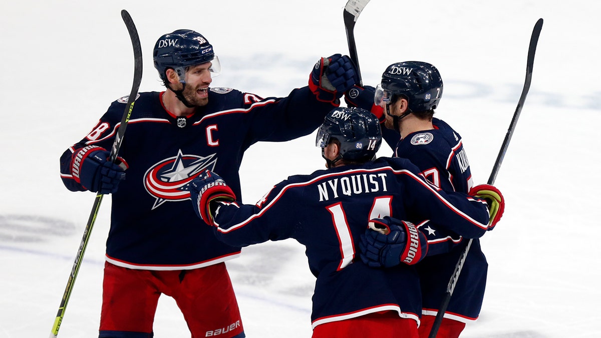 Columbus Blue Jackets forward Boone Jenner, left, celebrates with forward Gustav Nyquist, center, and forward Sean Kuraly after Kuraly's goal against the New York Rangers during the third period of an NHL hockey game in Columbus, Ohio, Thursday, Jan. 27, 2022. The Blue Jackets won 5-3.