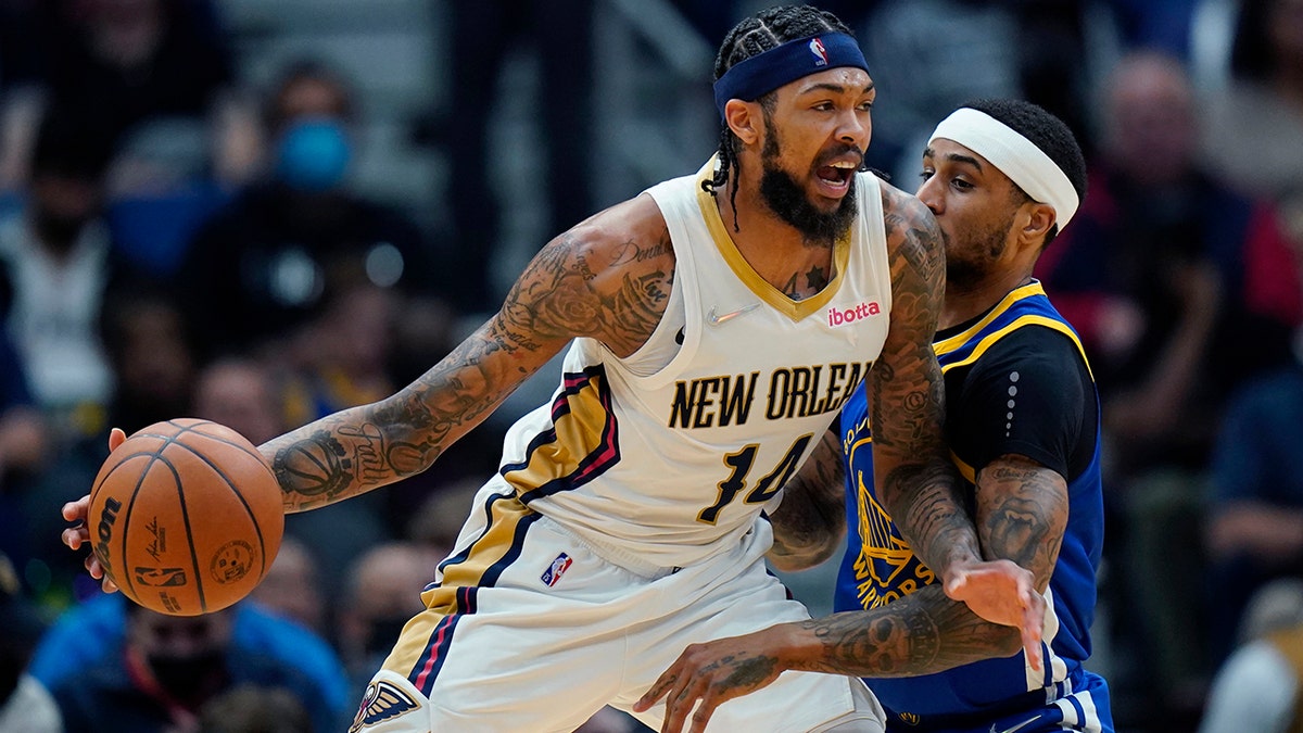 New Orleans Pelicans forward Brandon Ingram (14) drives to the basket against Golden State Warriors guard Gary Payton II in the first half of an NBA basketball game in New Orleans, Thursday, Jan. 6, 2022.