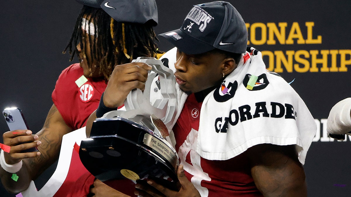 Alabama's Brian Robinson Jr. blows confetti off his outstanding offensive player trophy after the Cotton Bowl NCAA College Football Playoff semifinal game against Cincinnati, Friday, Dec. 31, 2021, in Arlington, Texas. Alabama won 27-6.