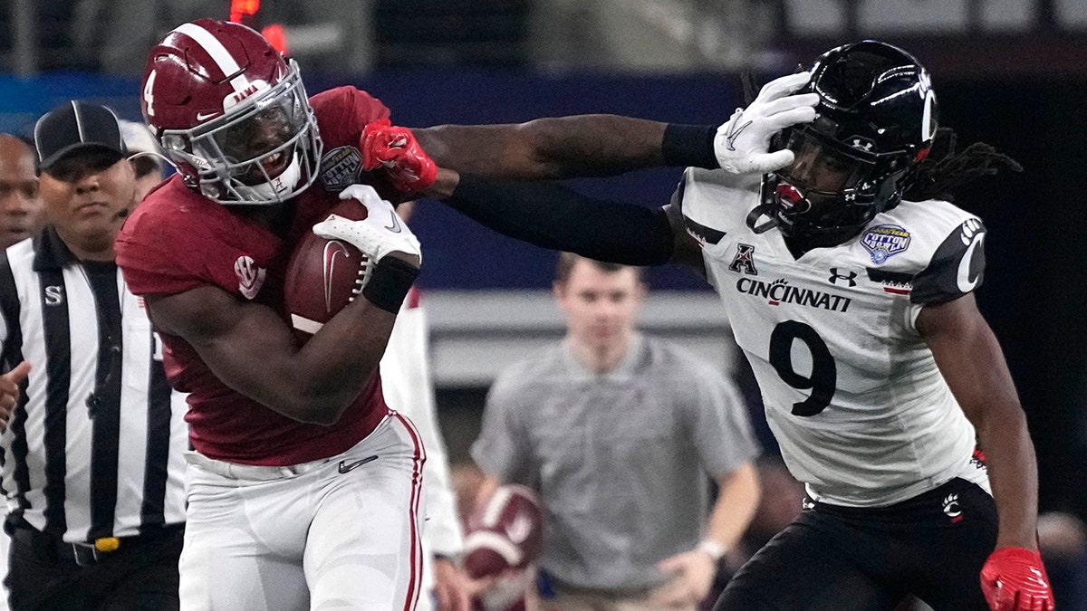 Cincinnati cornerback Arquon Bush (9) tries to tackled Alabama running back Brian Robinson Jr. (4) during the first half of the Cotton Bowl NCAA College Football Playoff semifinal game, Friday, Dec. 31, 2021, in Arlington, Texas.