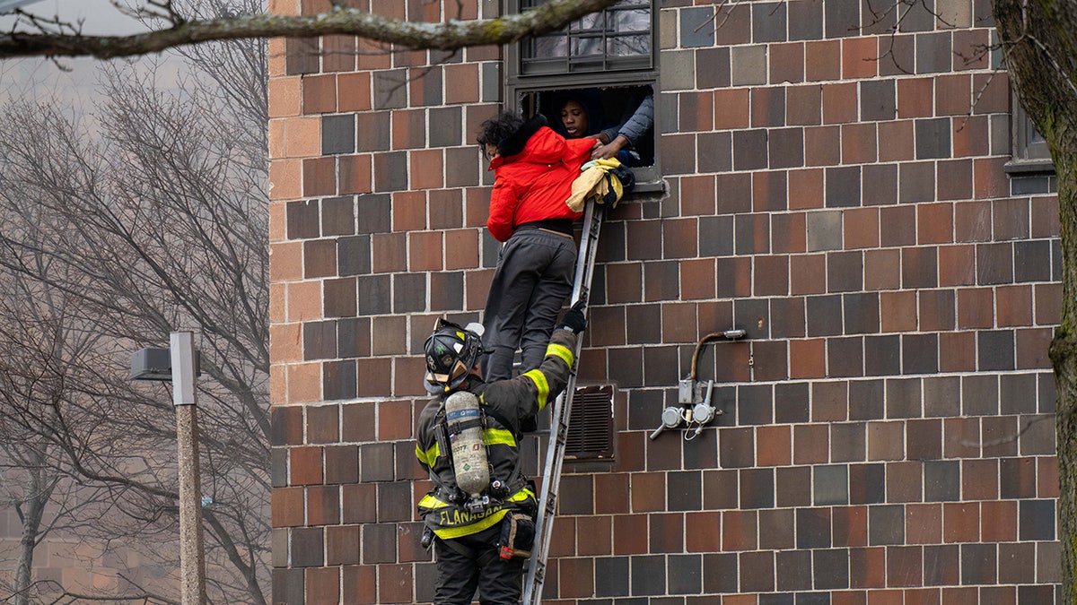 Firefighters hoisted a ladder to rescue people through their windows after a fire broke out inside a third-floor duplex apartment at 333 E. 181st St. in the Bronx Sunday