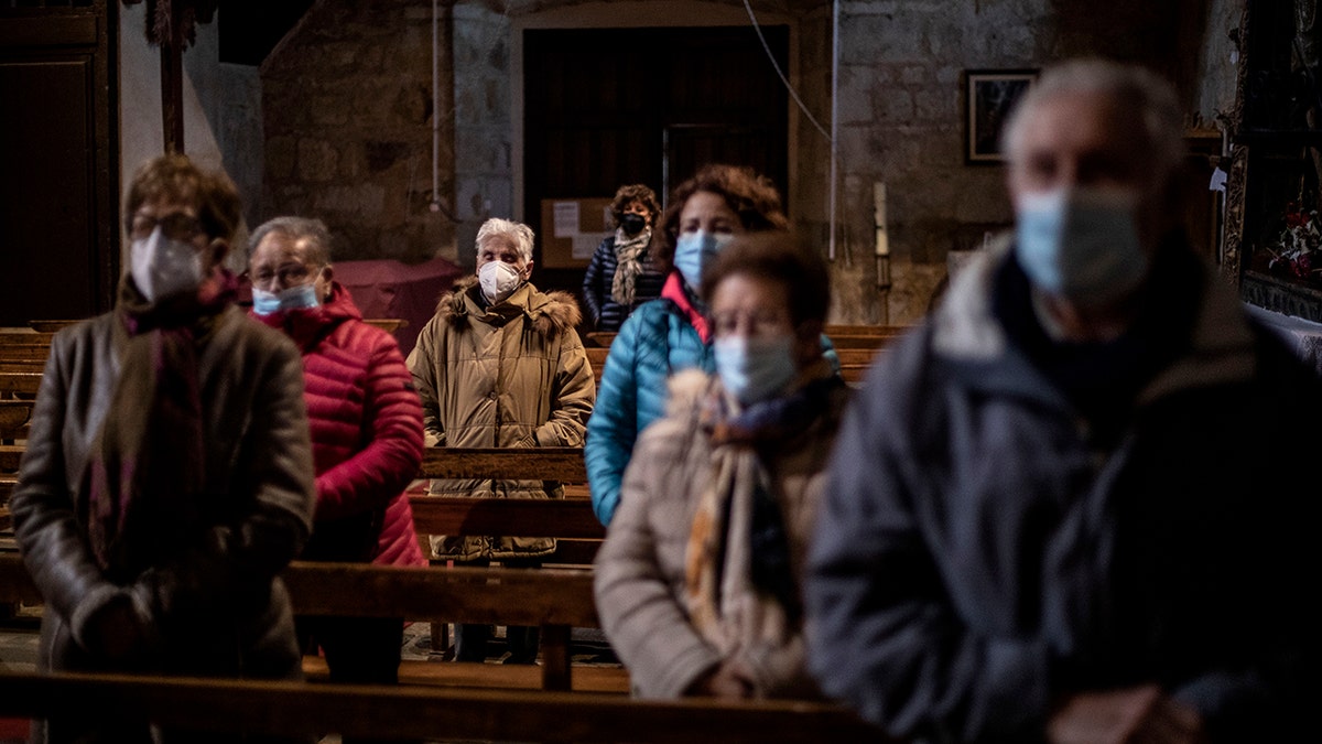 Parishioners stand while praying at the Saturday Mass the Catholic church of Cazurra, Spain