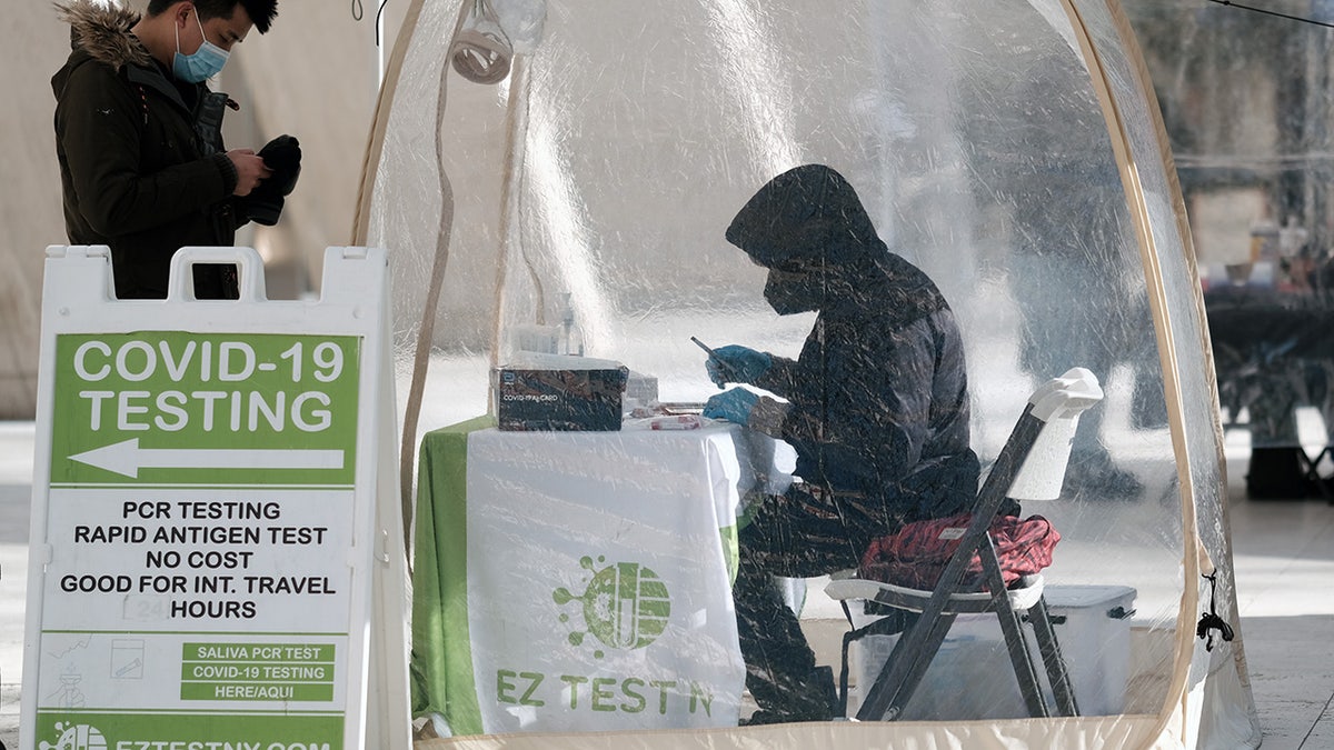 A person visits a COVID-19 testing site along a Manhattan street on Jan. 21, 2022, in New York City. 