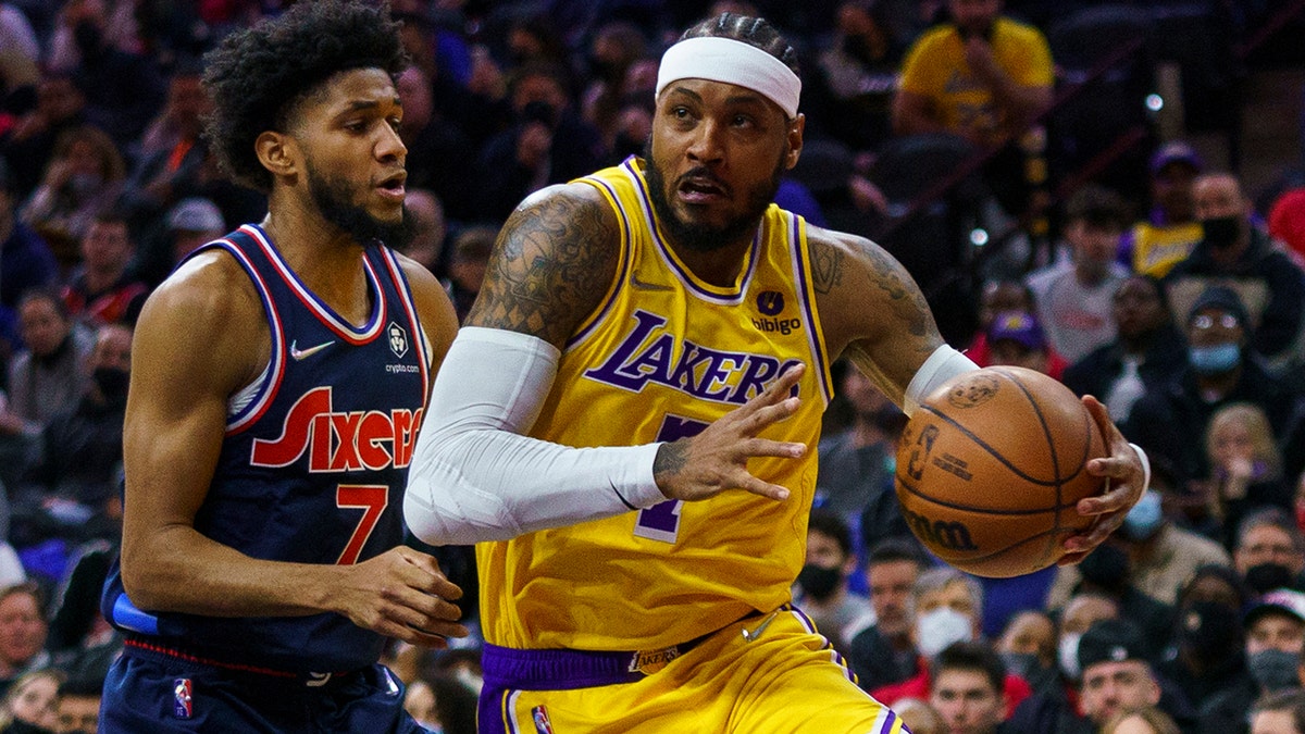 Los Angeles Lakers' Carmelo Anthony, right, drives to the basket against Philadelphia 76ers' Isaiah Joe, left, during the first half of an NBA basketball game, Thursday, Jan. 27, 2022, in Philadelphia.