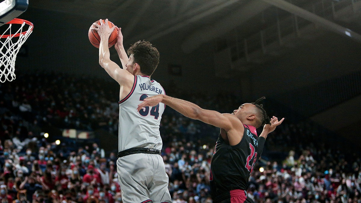 Gonzaga center Chet Holmgren, left, goes up for a dunk in front of Loyola Marymount guard Cam Shelton during the first half of an NCAA college basketball game, Thursday, Jan. 27, 2022, in Spokane, Wash.