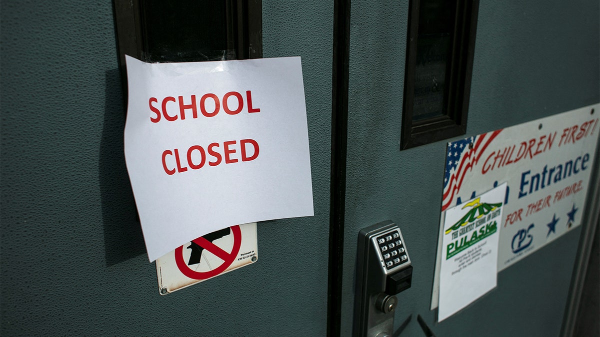 A sign taped to the front door of Pulaski International School of Chicago reads, 