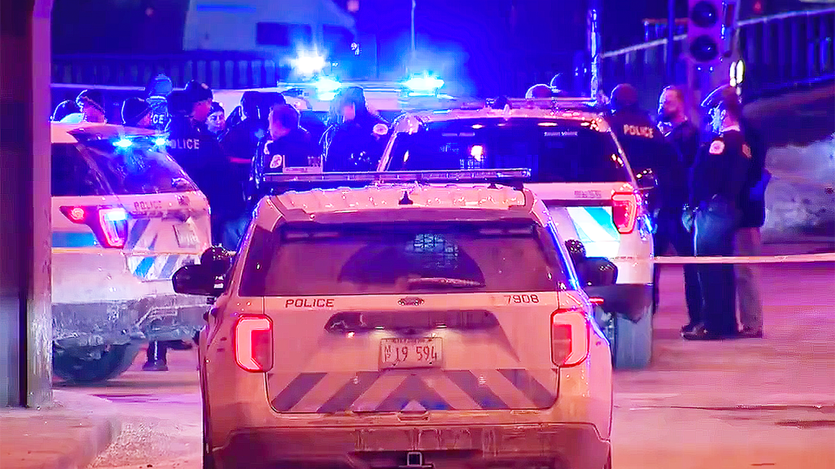 Chicago police cars with their lights on respond to a suspected carjacking and shooting