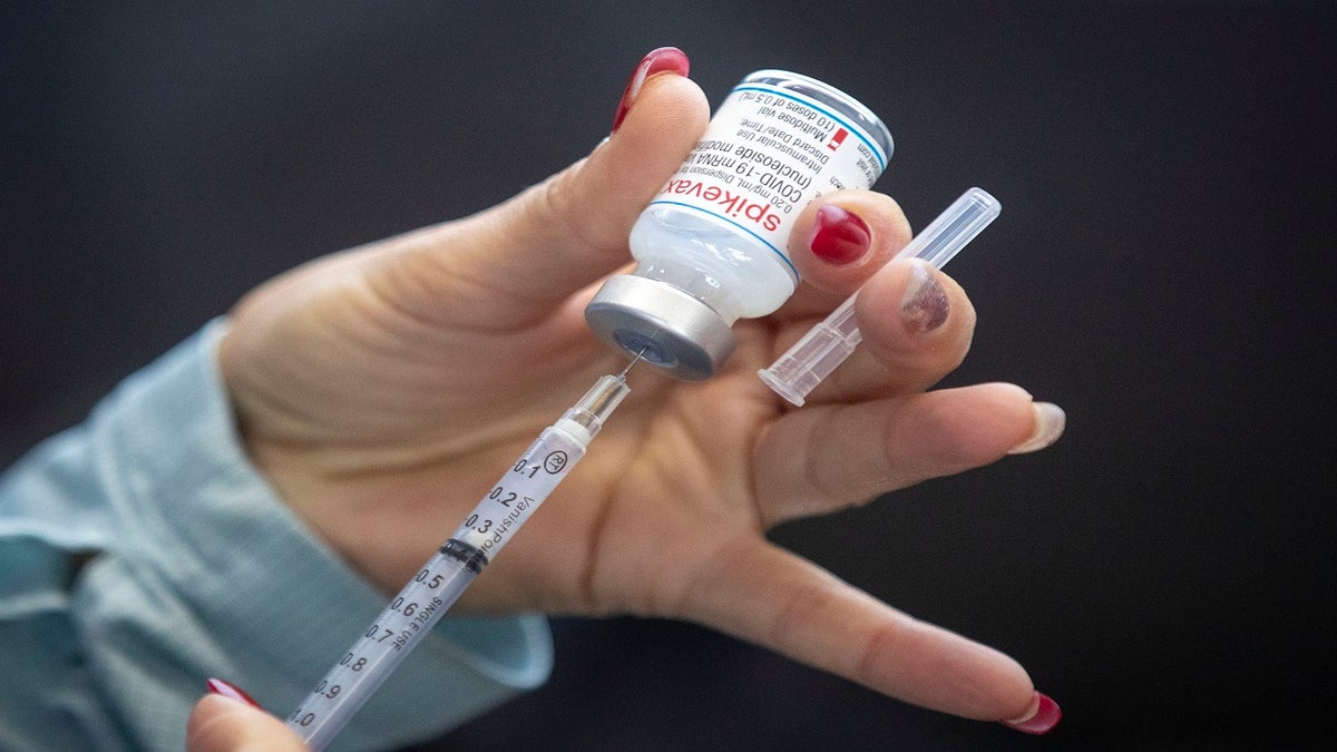 A person draws out Moderna vaccine during a drive through COVID-19 vaccine clinic at St. Lawrence College in Kingston, Ontario, on Sunday.