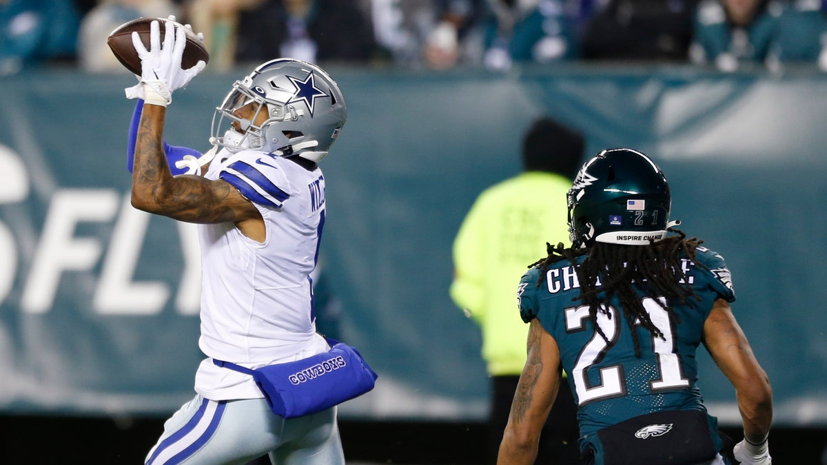 Dallas Cowboys wide receiver Ced Wilson catches a pass over Philadelphia Eagles defensive back Andre Chachere to score a touchdown during the first half of an NFL football game, Saturday, Jan. 8, 2022, in Philadelphia. (AP Photo/Laurence Kesterson)