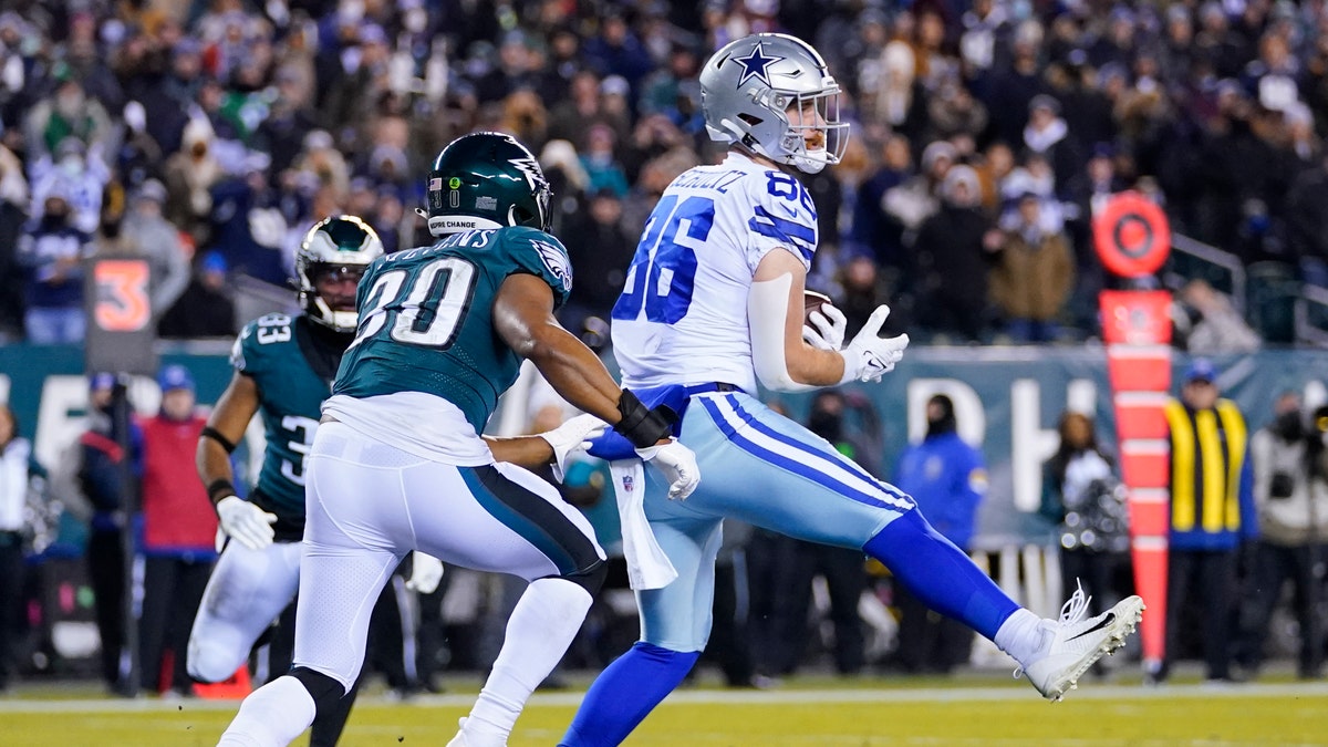 Dallas Cowboys tight end Dalton Schultz, right, catches a touchdown pass over Philadelphia Eagles linebacker JaCoby Stevens, left, during the first half of an NFL football game, Saturday, Jan. 8, 2022, in Philadelphia. (AP Photo/Julio Cortez)