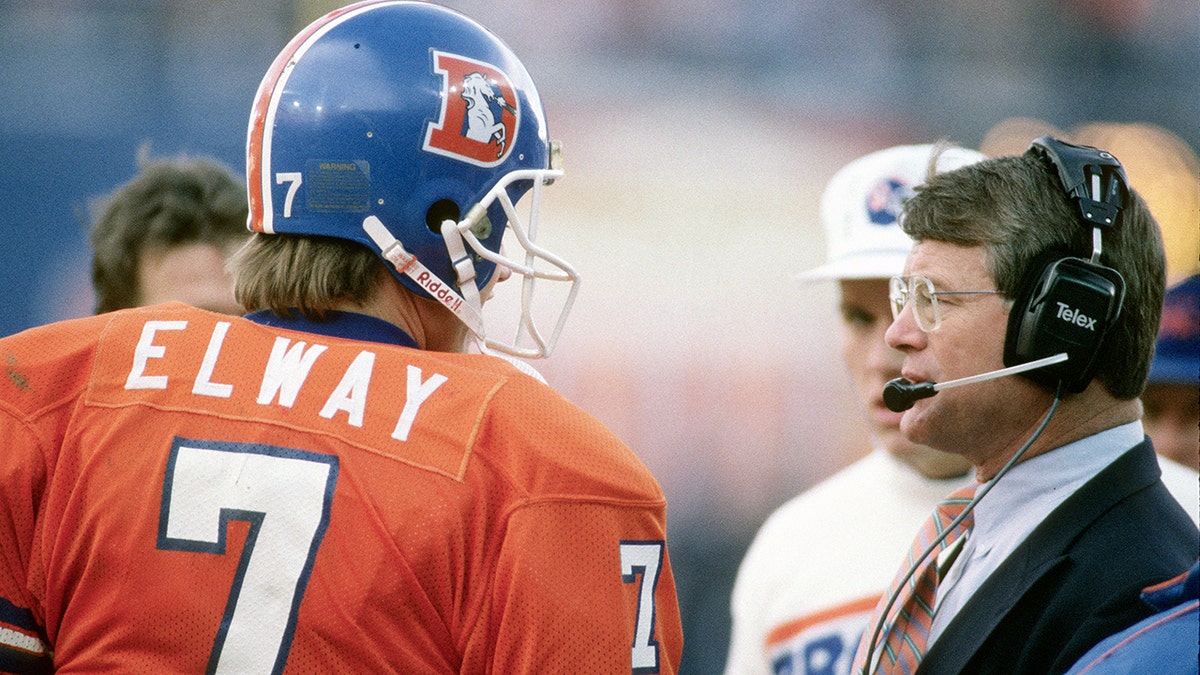 Head coach Dan Reeves of the Denver Broncos talks with his quarterback John Elway circa 1988 at Mile High Stadium in Denver, Colorado. Reeves was the head coach of the Denver Broncos from 1981-92. 