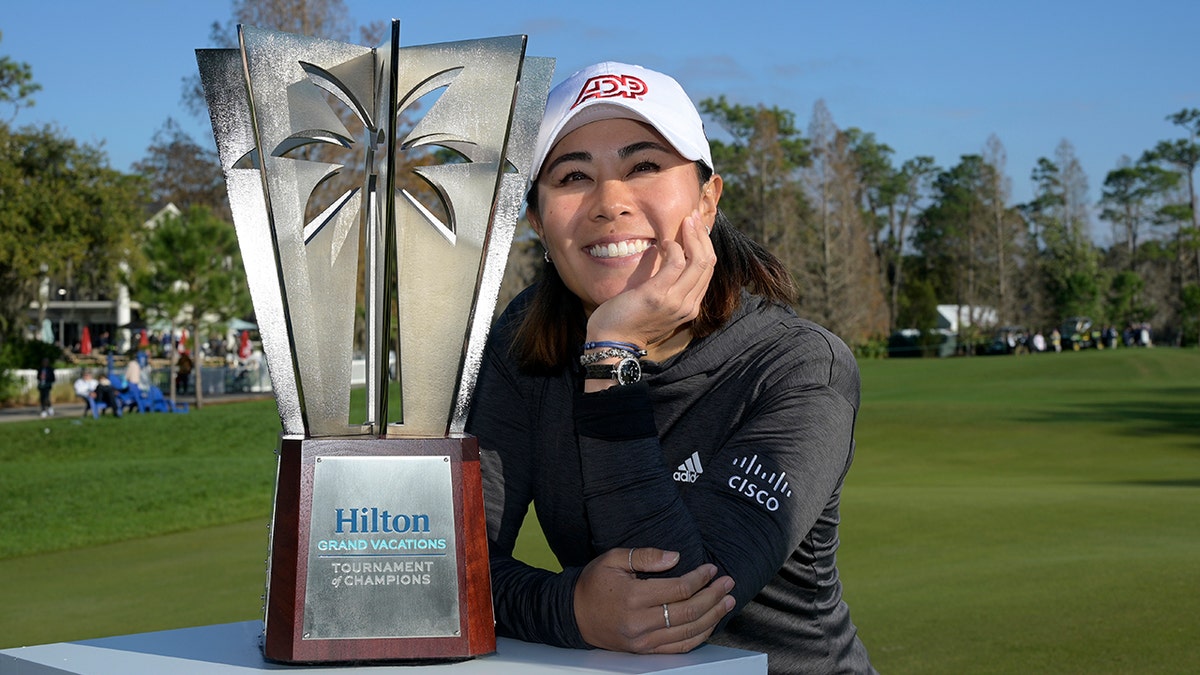 Danielle Kang poses next to the championship trophy on the 18th green after winning the Tournament of Champions LPGA golf tournament, Sunday, Jan. 23, 2022, in Orlando, Fla.