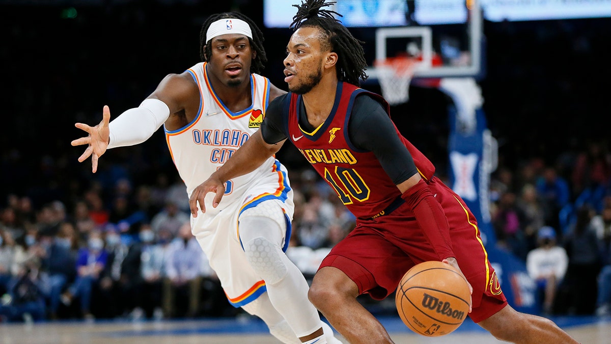 Cleveland Cavaliers guard Darius Garland (10) drives against Oklahoma City Thunder guard Luguentz Dort in the first half of an NBA basketball game Saturday, Jan. 15, 2022, in Oklahoma City.
