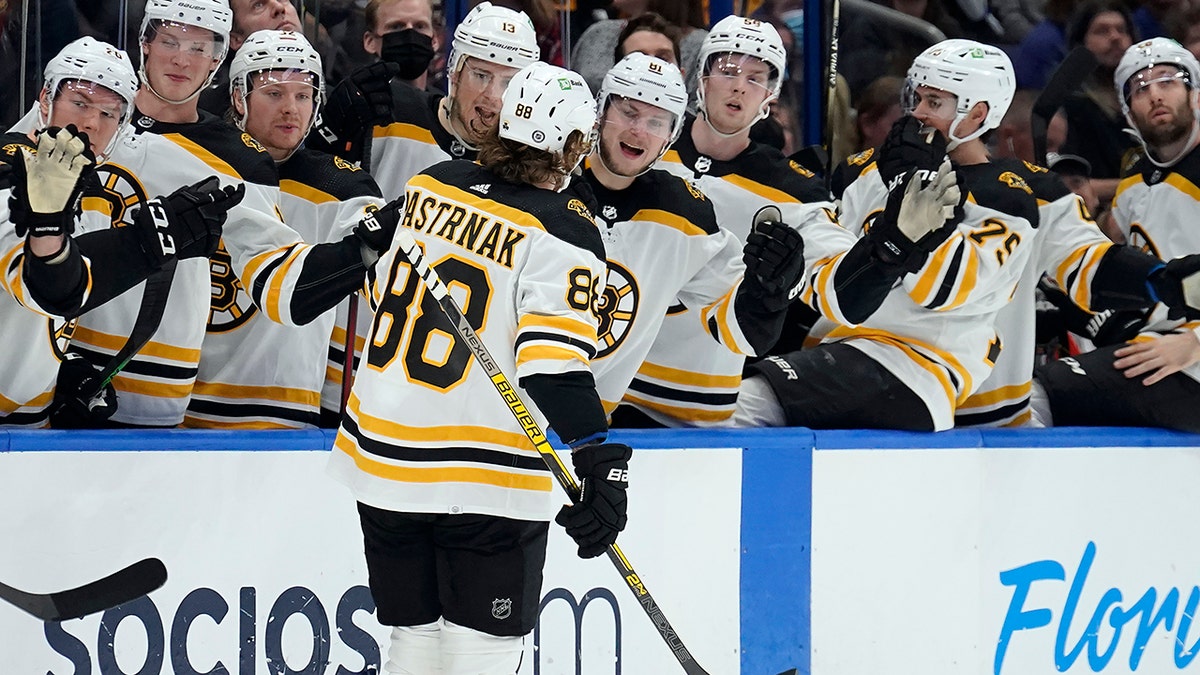 Boston Bruins right wing David Pastrnak (88) celebrates with the bench after his goal against the Tampa Bay Lightning during the first period of an NHL hockey game Saturday, Jan. 8, 2022, in Tampa, Fla.
