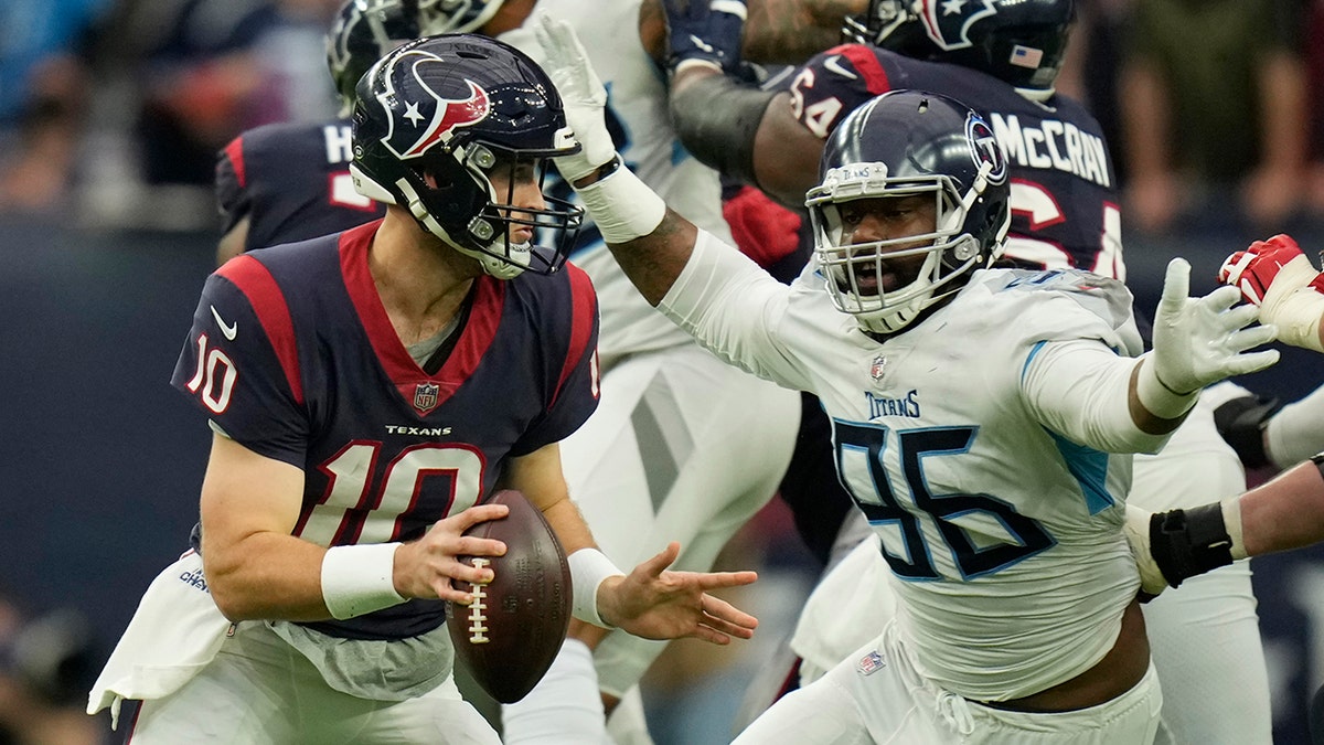 Houston Texans quarterback Davis Mills (10) is pressured by Tennessee Titans defensive end Denico Autry (96) during the second half Sunday, Jan. 9, 2022, in Houston.