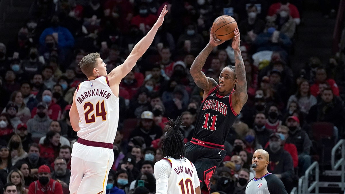 Chicago Bulls' DeMar DeRozan (11) passes under pressure from Cleveland Cavaliers' Lauri Markkanen (24) as Darius Garland (10) also defends during the first half of an NBA basketball game Wednesday, Jan. 19, 2022, in Chicago.