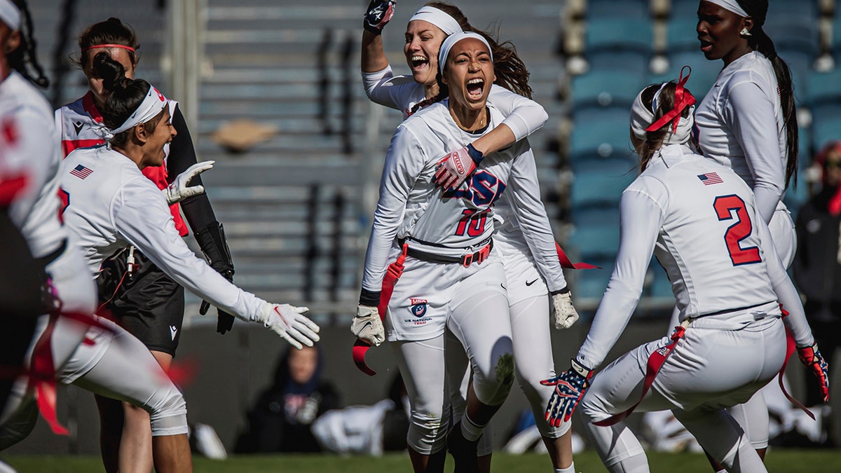 This handout provided by USA Football shows U.S. women's flag football team defensive back Deliah Autry (10) of Tampa, Fla., celebrating with teammates during a game against Austria at the International Federation of American Football Flag Football world championships in Jerusalem, Israel, Dec. 8, 2021.  The NFL is helping wave the flag for flag football to become part of the Olympics. The target is the 2028 Summer Games in Los Angeles.