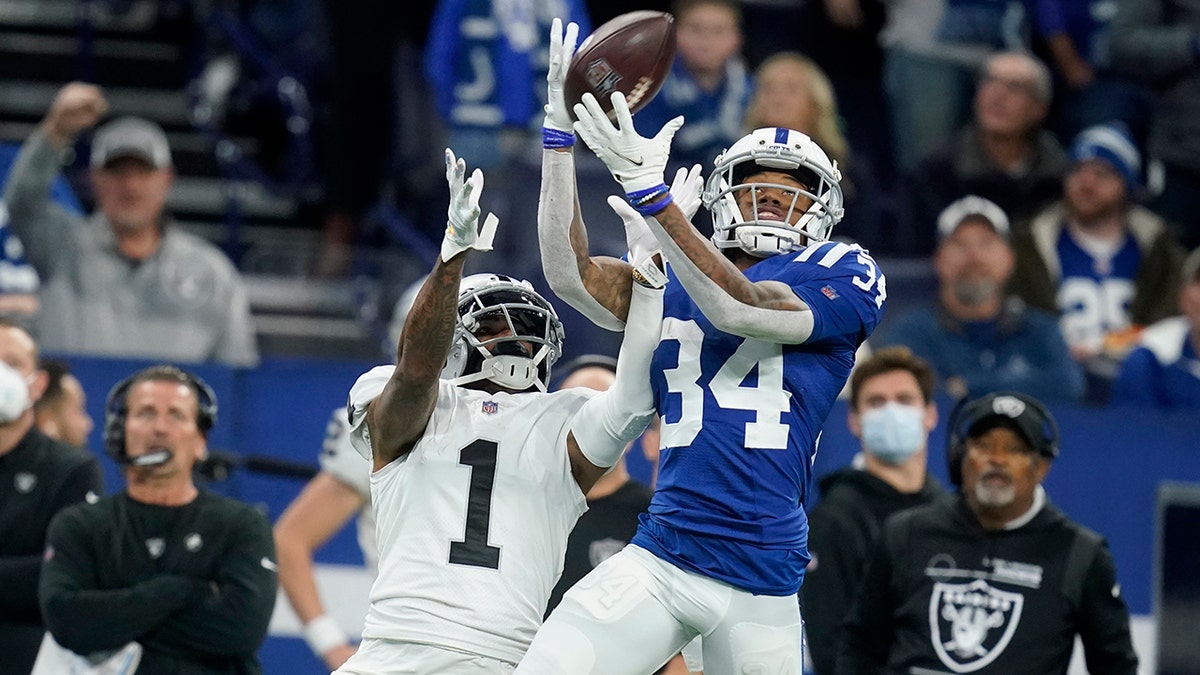 Indianapolis Colts cornerback Isaiah Rodgers (34) intercepts a pass intended for Las Vegas Raiders wide receiver DeSean Jackson (1) during the first half of an NFL football game, Sunday, Jan. 2, 2022, in Indianapolis.
