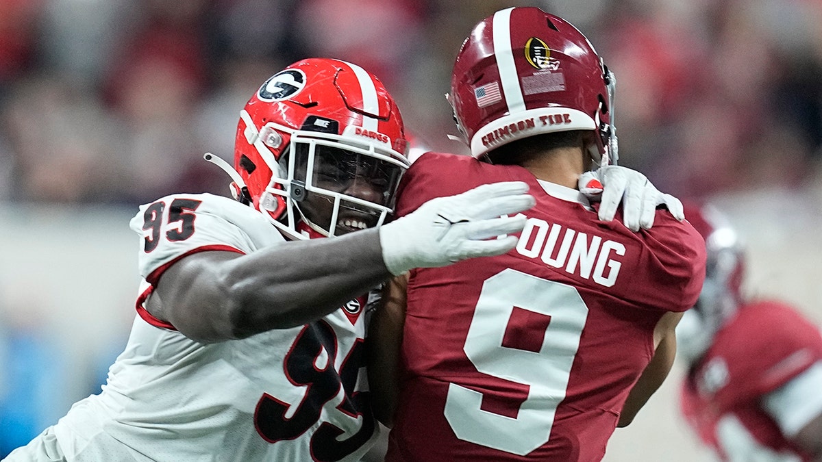 Georgia's Devonte Wyatt hits Alabama's Bryce Young as he throws during the first half of the College Football Playoff championship football game Monday, Jan. 10, 2022, in Indianapolis. 