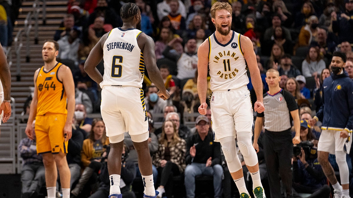 Indiana Pacers forward Domantas Sabonis (11), right, reacts after scoring during the second half of an NBA basketball game against the Utah Jazz in Indianapolis, Saturday, Jan. 8, 2022.