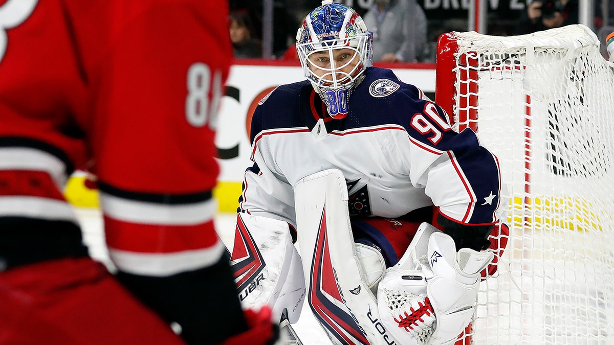 Columbus Blue Jackets goaltender Elvis Merzlikins (90) watches the puck controlled by Carolina Hurricanes' Martin Necas (88) during the second period of an NHL hockey game in Raleigh, N.C., Thursday, Jan. 13, 2022.