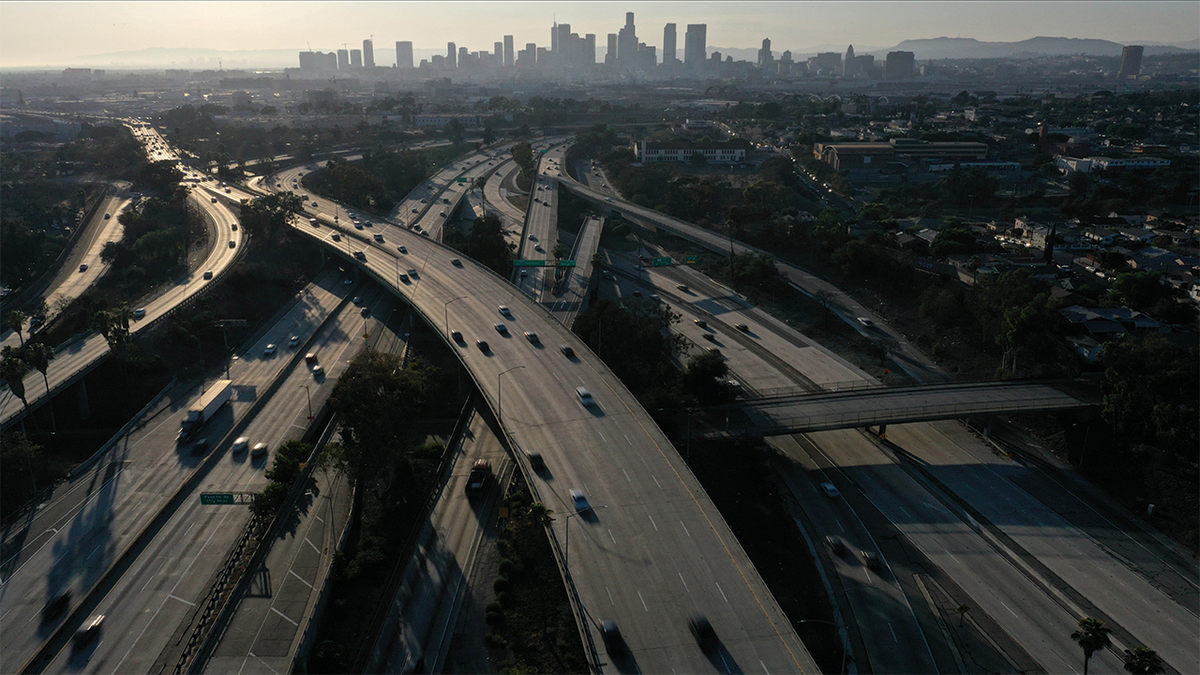 An aerial view shows the LA skyline and traffic on the East Los Angeles Interchange complex, the busiest freeway interchange in the world, Los Angeles, California, U.S. August 10, 2021.