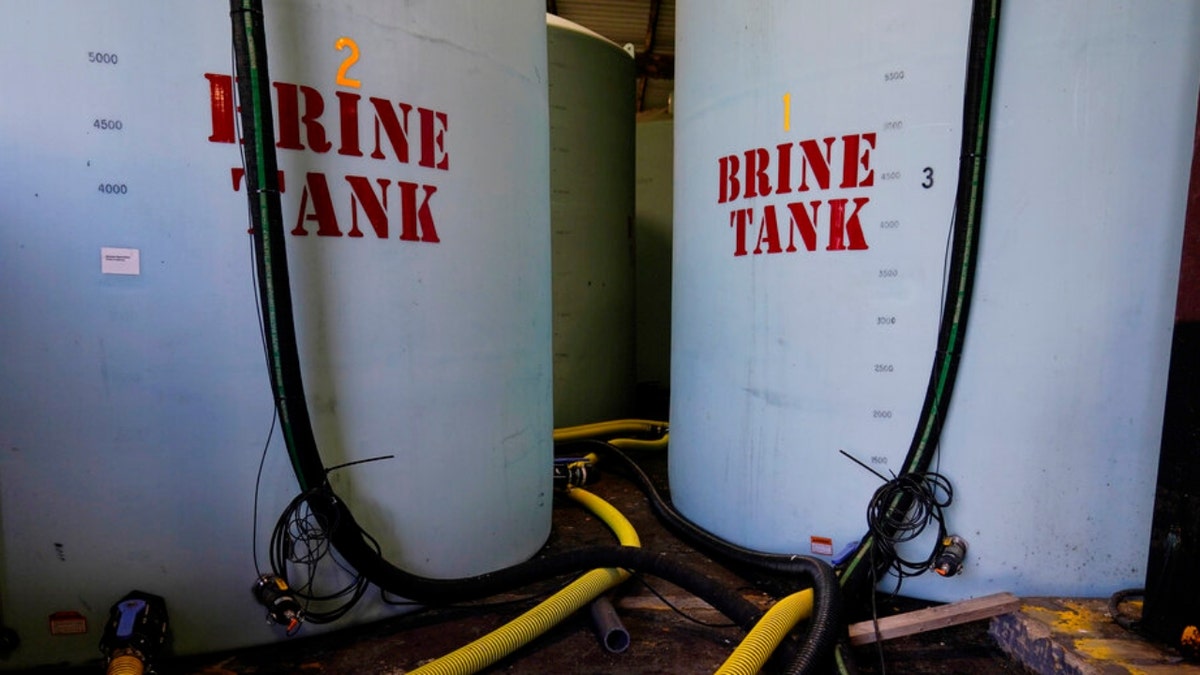 Hoes used to fill brine are seen near brine tank storage bins ahead of a winter storm at the GDOT’s Maintenance Activities Unit location on Friday, Jan. 14, 2022, in Forest Park, Ga. A winter storm is headed south that could effect much of Georgia thru Sunday.