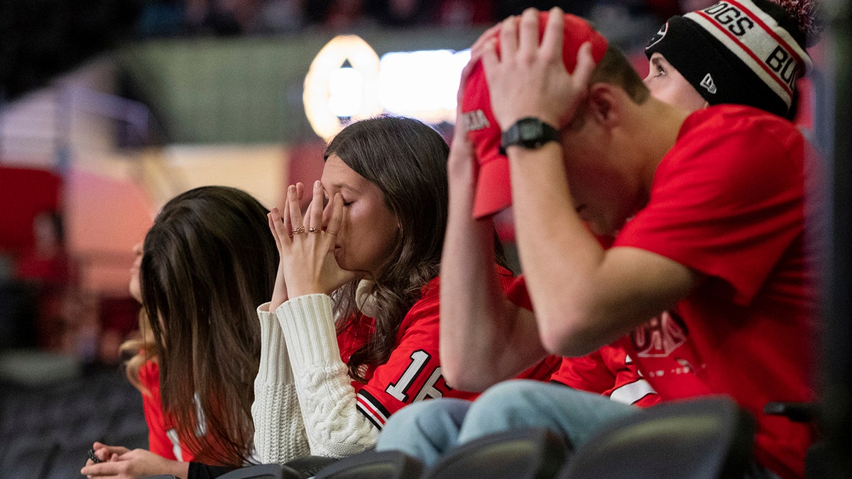 Fans at the University of Georgia's coliseum in Athens, Ga., hold their heads after Alabama converted a first down during the second half of the College Football Playoff championship game Monday, Jan. 10, 2022.