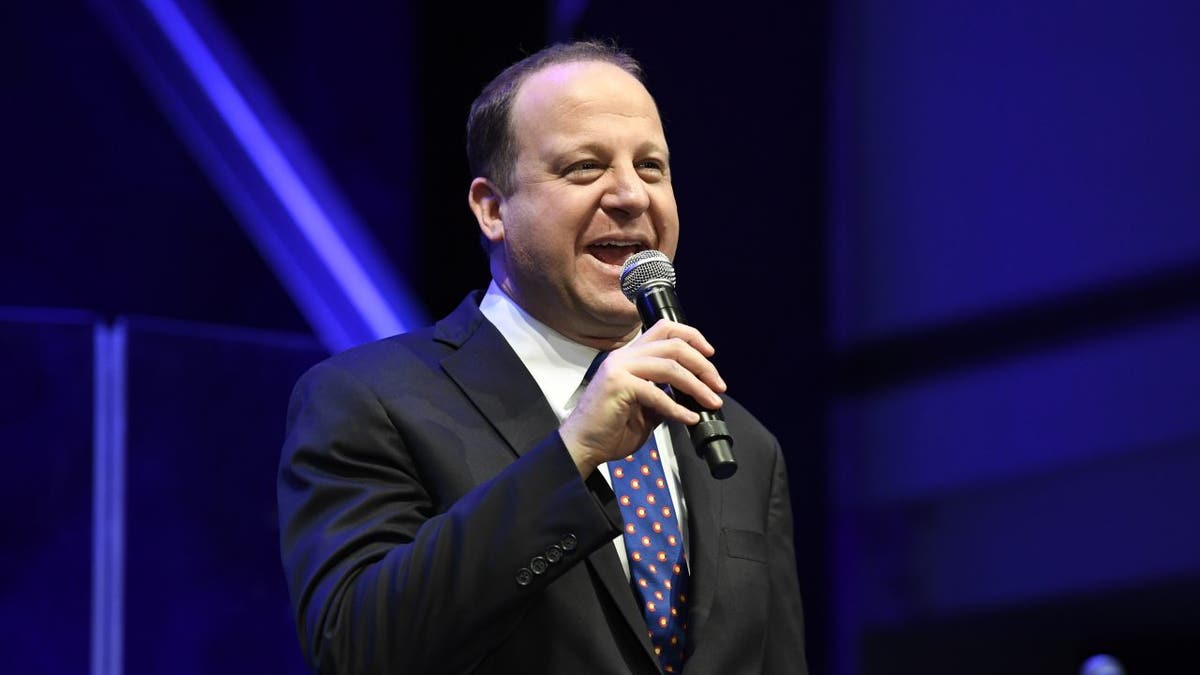 Gov. Jared Polis of Colorado holding microphone