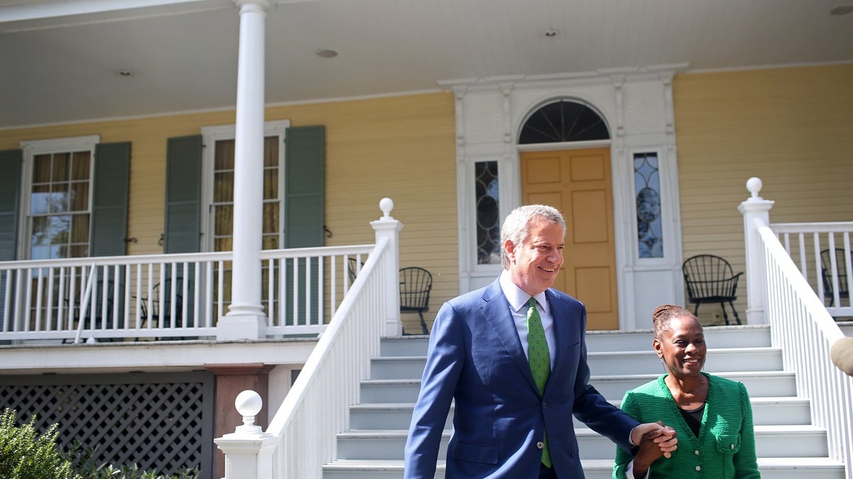 New York City Mayor Bill de Blasio arrives with his wife, Chirlane McCray, to a press conference in front of Gracie Mansion on Sept. 20, 2019, in New York City.