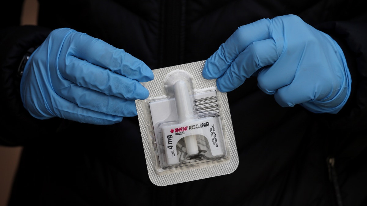 BOSTON, MA - MARCH 31: Outreach specialist Rachel Bolton displays a dose of NARCAN outside the Access Drug User Health Program drop in center in Cambridge, MA on March 31, 2020. She and site coordinator Josh Ledesma use bicycles to deliver safe injection supplies, NARCAN® (naloxone) and hygiene kits to people with addiction. (Photo by Craig F. Walker/The Boston Globe via Getty Images)