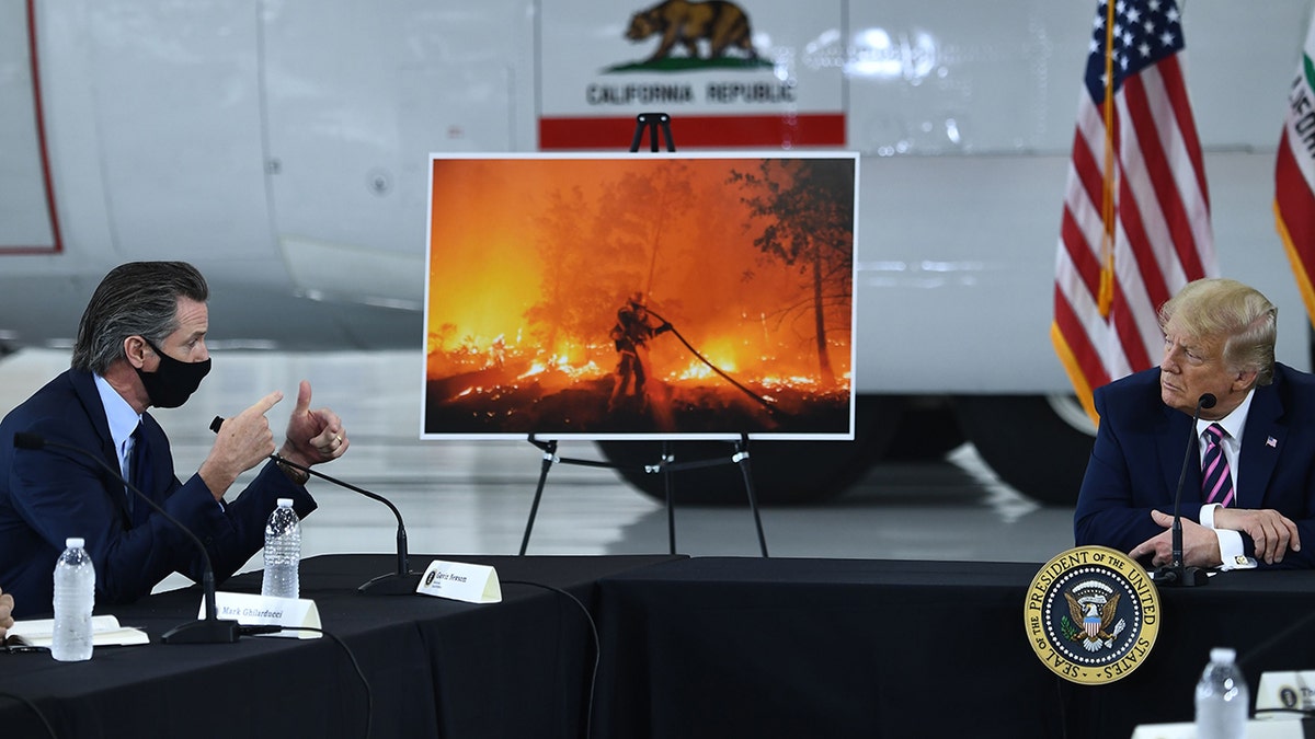 Then-President Trump, right, speaks with California Gov. Gavin Newsom at Sacramento McClellan Airport in McClellan Park, California, during a briefing on wildfires, Sept. 14, 2020.